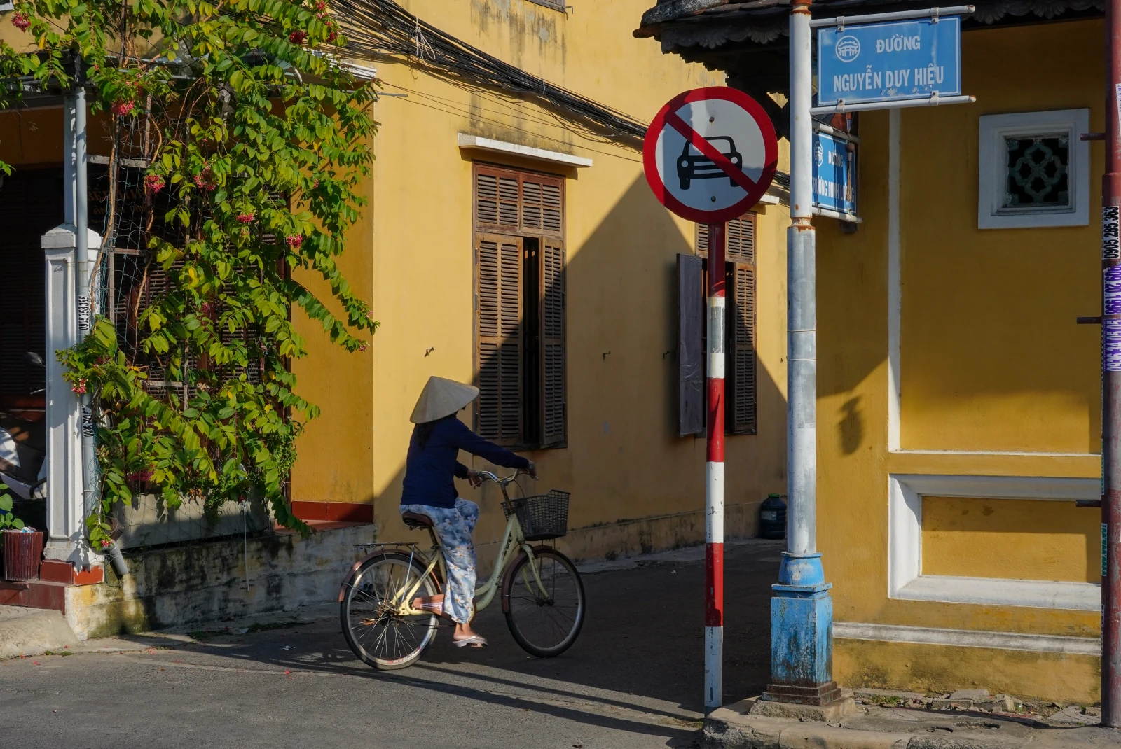Woman riding a bike next to yellow buildings during daytime