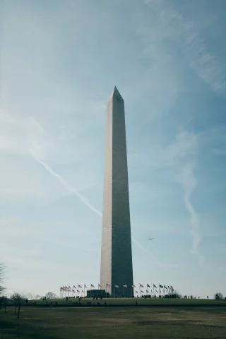 Washington Monument with a plane in the background

