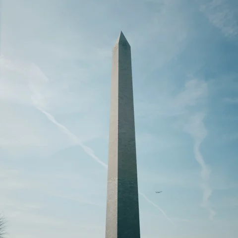 Washington Monument with a plane in the background


