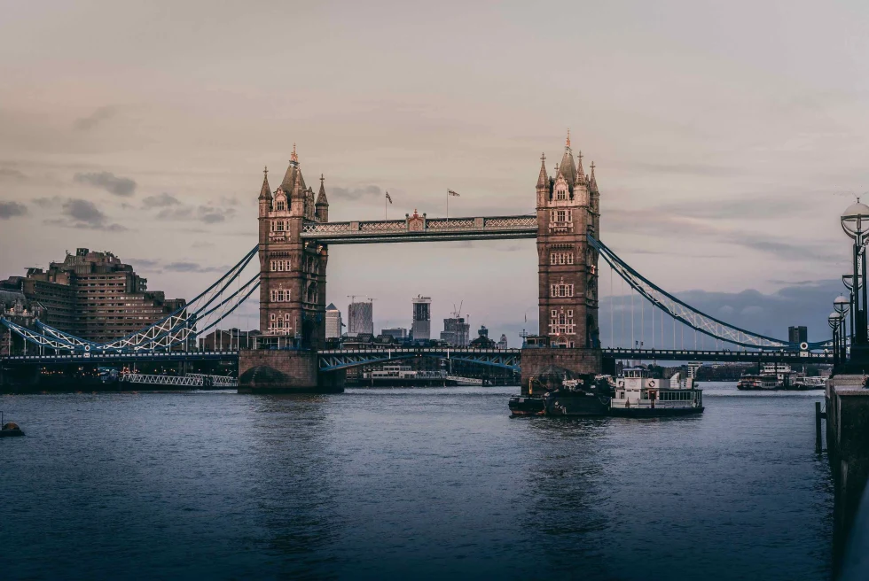 bridge over body of water with cloudy skies