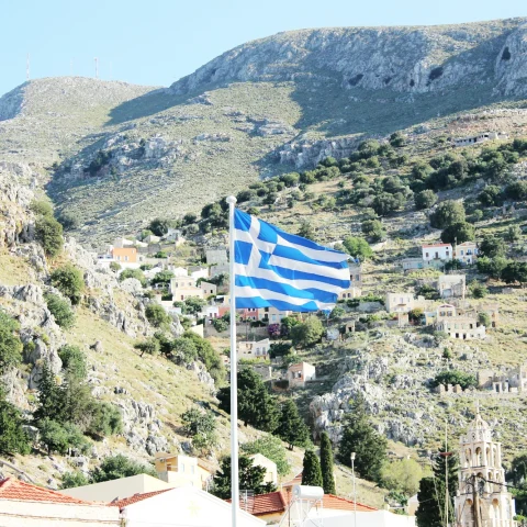 country side with Greece flag waving