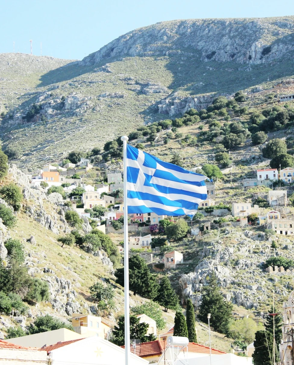 country side with Greece flag waving