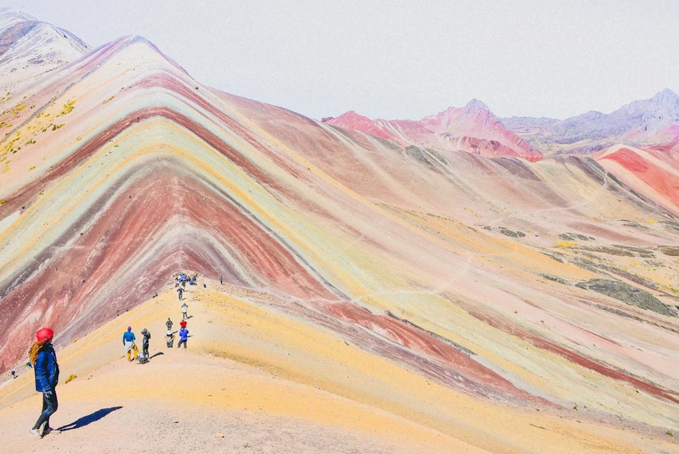 Tourists trekking on Rainbow Mountain on a bright day.