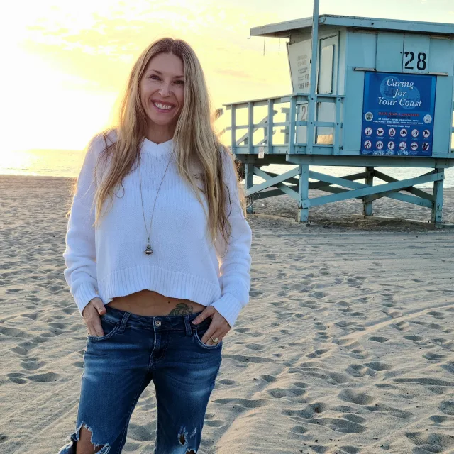 Ali Lefebvre posing for a picture on the beach.