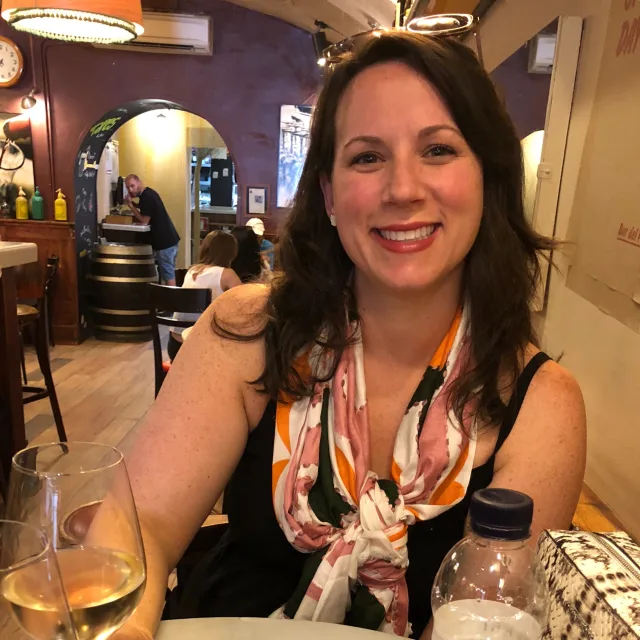 Travel advisor Mary Alise Snyder smiling with a glass of white wine