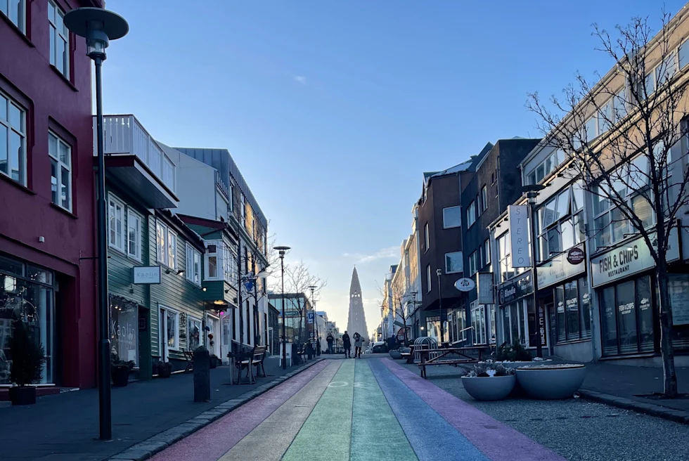 a long street painted rainbow leading towards a monument