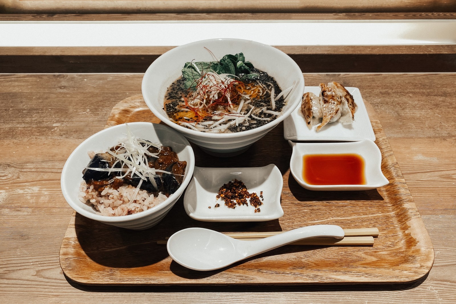 bowls of noodles and sauces on wooden table