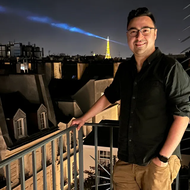 Travel advisor Alex Raup standing in a balcony wearing black formal shirt.