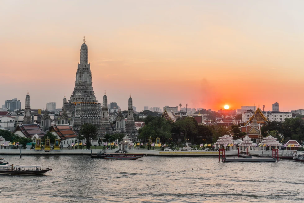 temples and buildings next to body of water during sunset