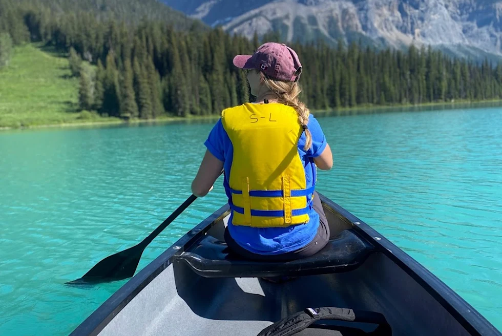 A girl kayaking on a lake.