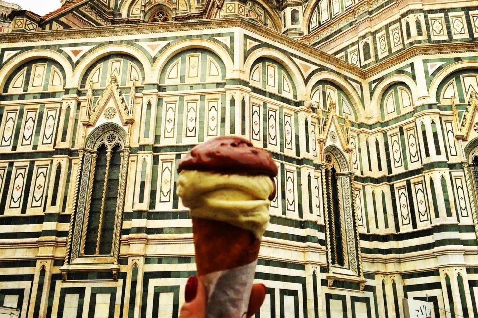 a cone of ice cream in front of an ornate building