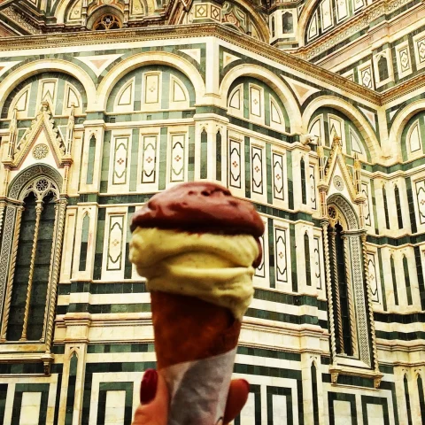 a cone of ice cream in front of an ornate building