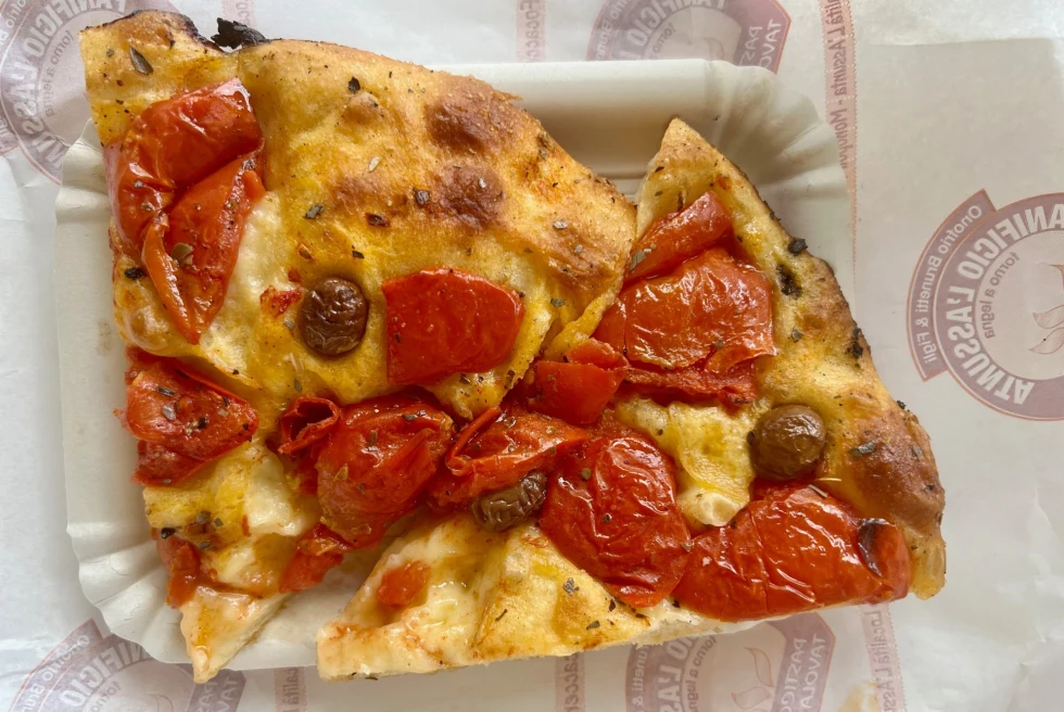 A close shot of focaccia covered in tomatoes.