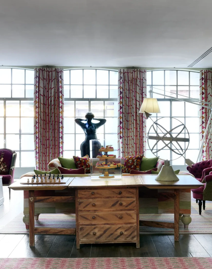 a luxe dining area with floor-to-ceiling windows and a smooth stone sculpture of a woman
