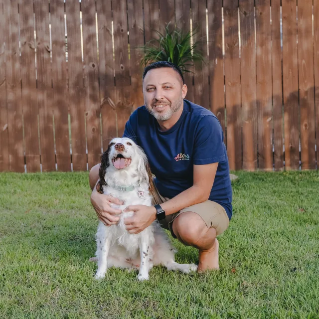 Advisor posing and smiling with a dog