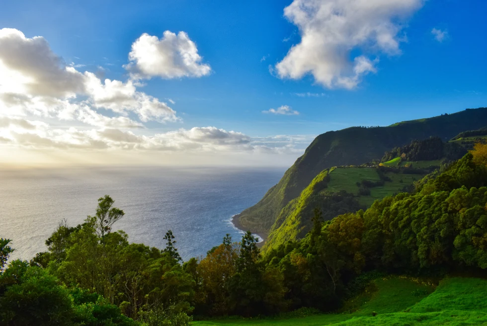 View of mountain and ocean with blue skies