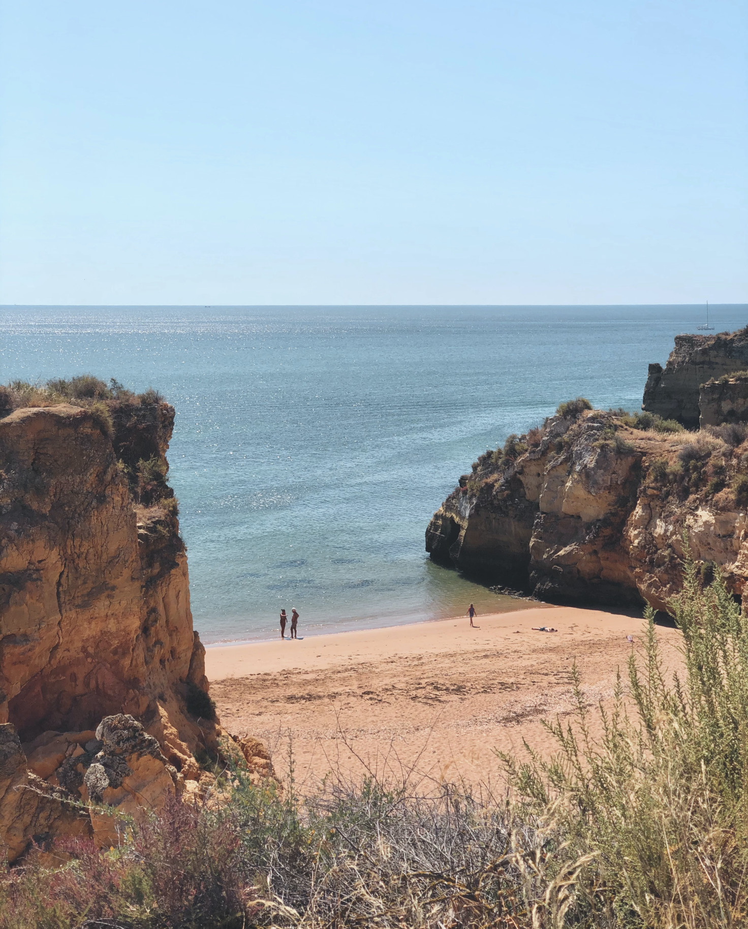 people on beach next to body of water during daytime