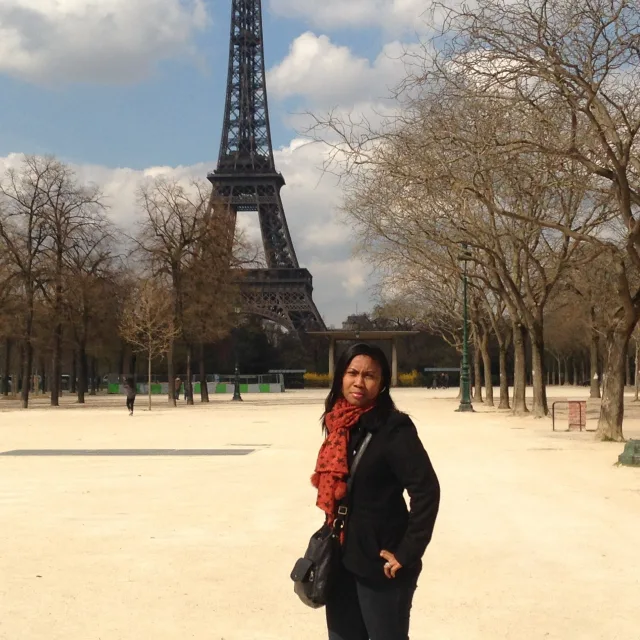 Picture of Lola wearing a red scarf in front of the Eiffel Tower