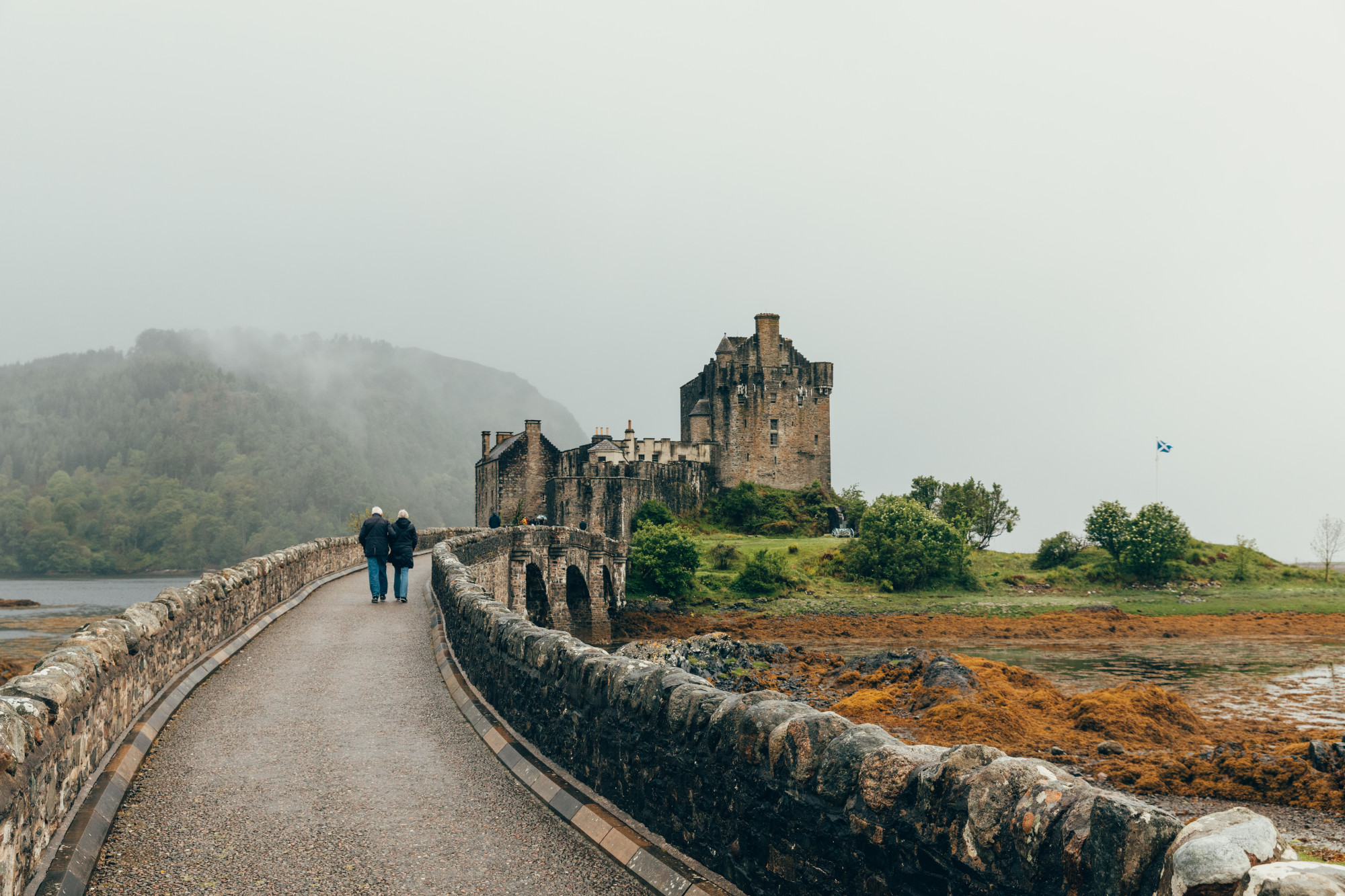 people walking on a bridge on a rainy day