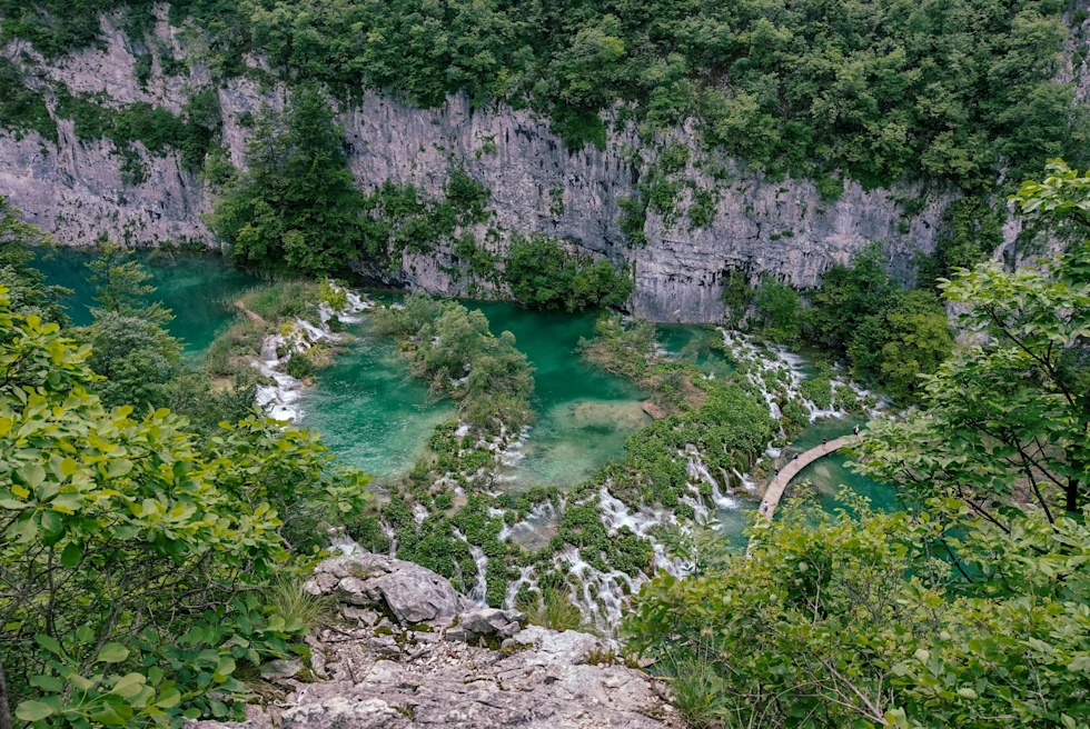 Aerial view of a lake among mountains with trees.