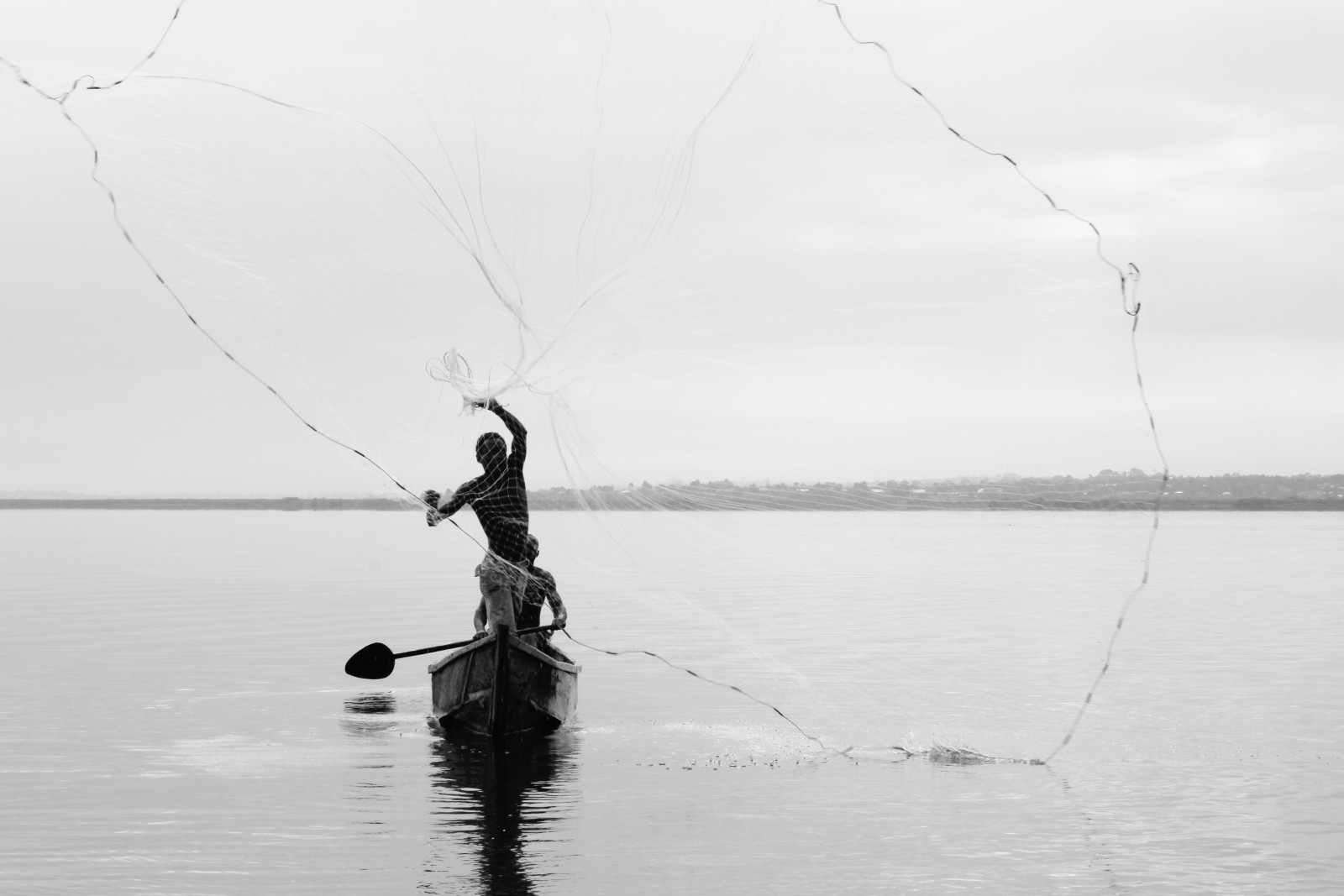 Man stands in canoe in Lake Victoria in Uganda
