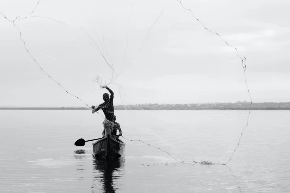 Man stands in canoe in Lake Victoria in Uganda
