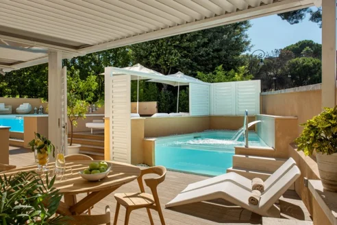 wooden pool deck with tables and chairs