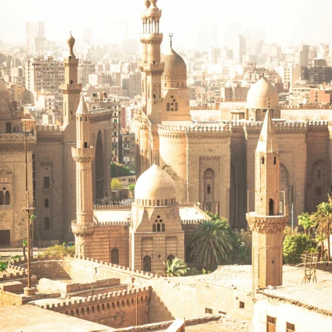 rooftop view of ancient desert city punctuates with tall steeples of mosques 