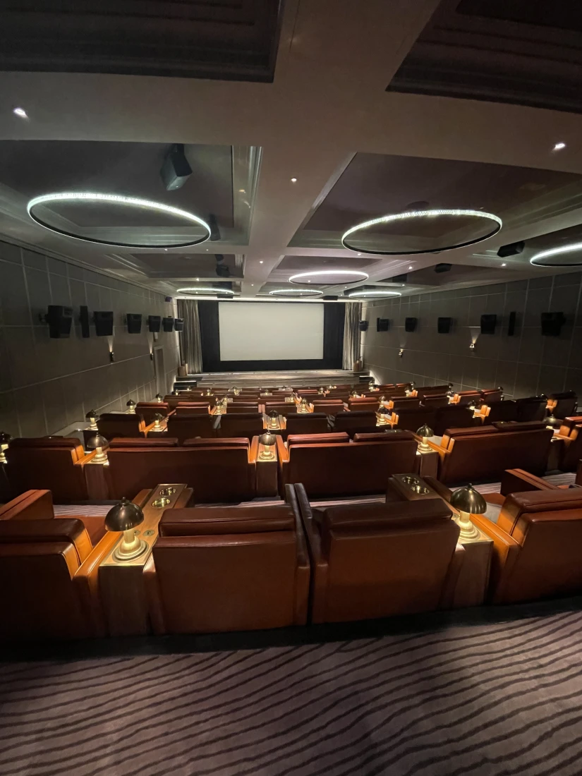 Theater room with large leather chairs and a screen