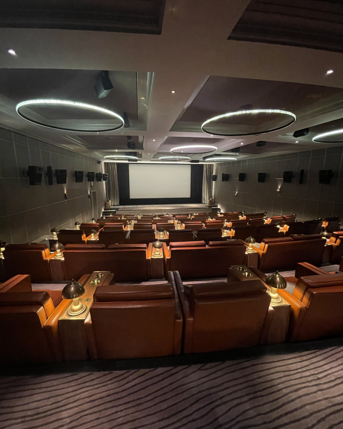 Theater room with large leather chairs and a screen