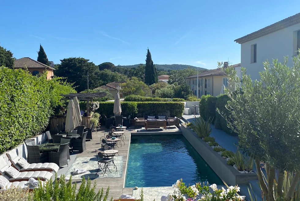 A small pool with lounging chairs.