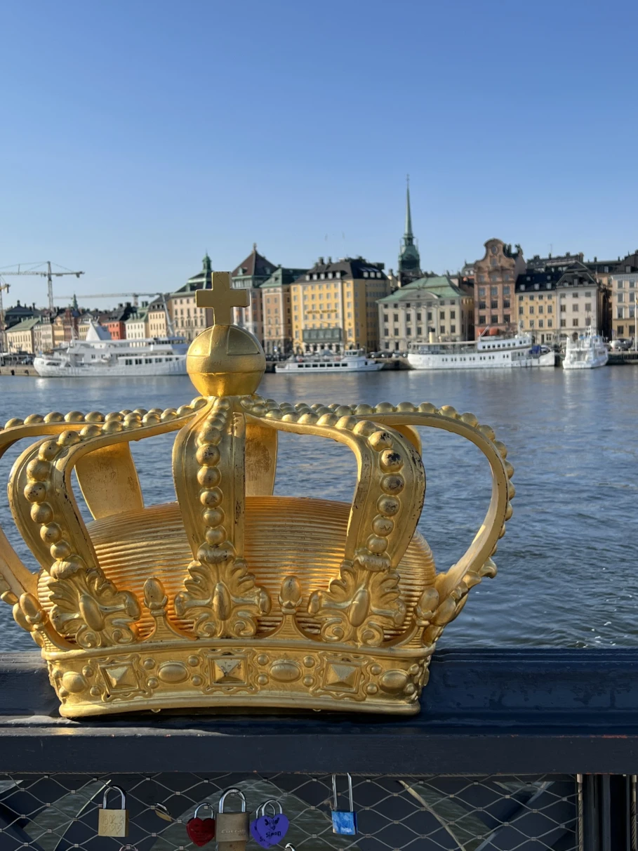 Statue of a golden crown on a bridge.