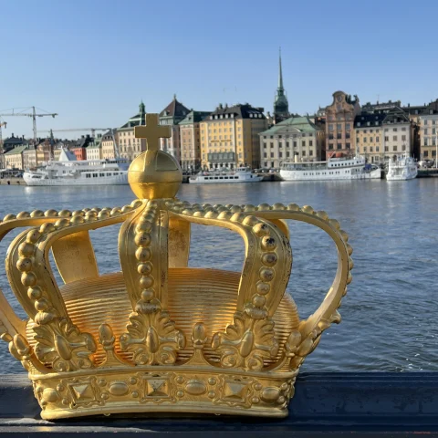 Statue of a golden crown on a bridge.