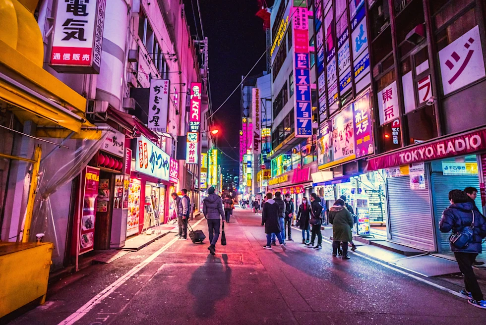 Busy downtown Japan, Tokyo featuring neon lights at night.