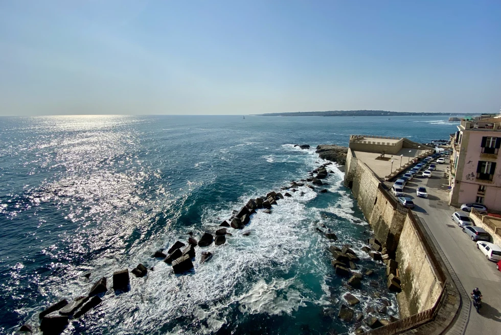 A coastal road with cars next to the sea.