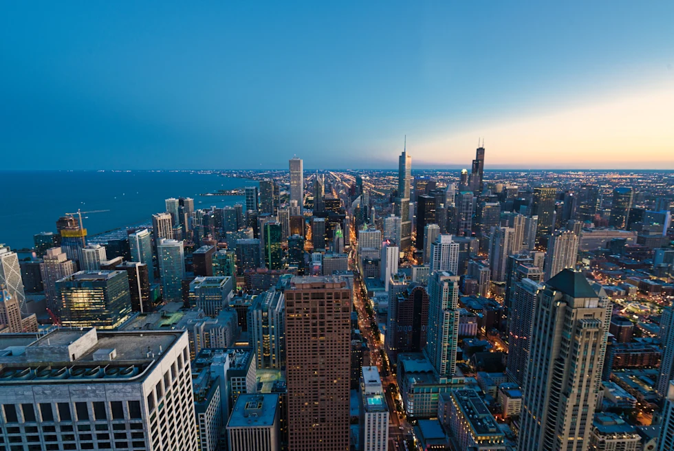 aerial view of buildings next to the water during sunset