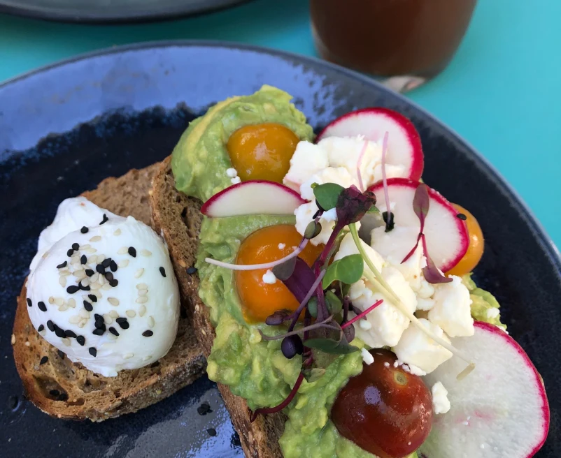 avocado toast with radish, tomatoes, egg and cheese