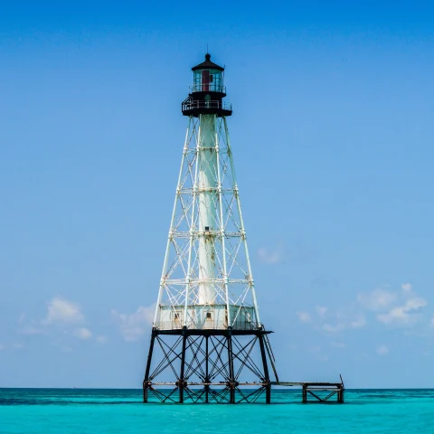 Lighthouse in bright blue waters on a sunny day in Islamorada