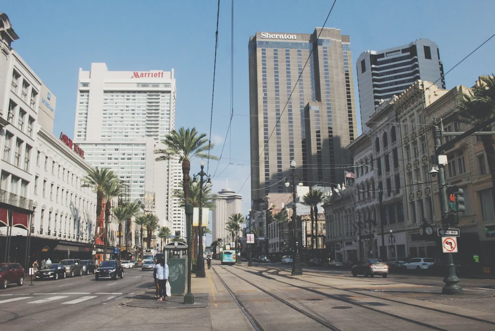 Buildings in an Urban Area with cars and people walking on street.