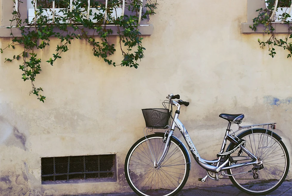 bike against a stone wall with window boxes above