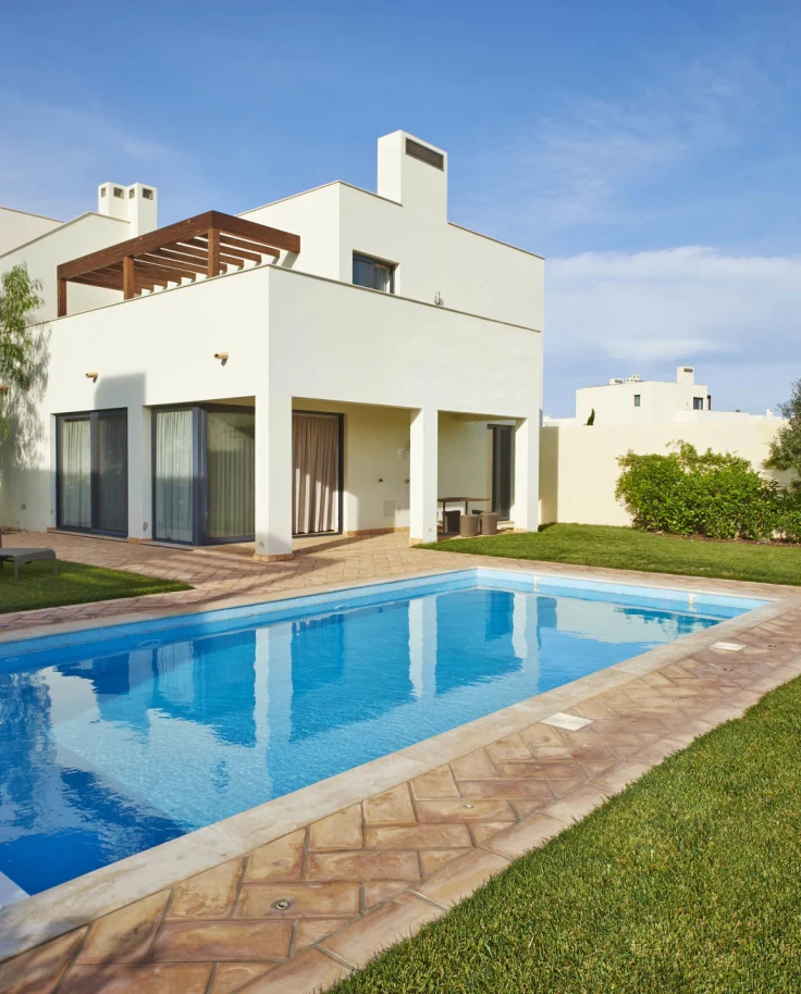 White modern villa with long private pool in Martinhal Sagres in Portugal on a sunny day. 