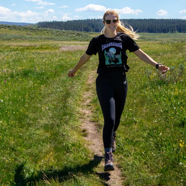 Travel Advisor Nicole Mattia in black running through a field.