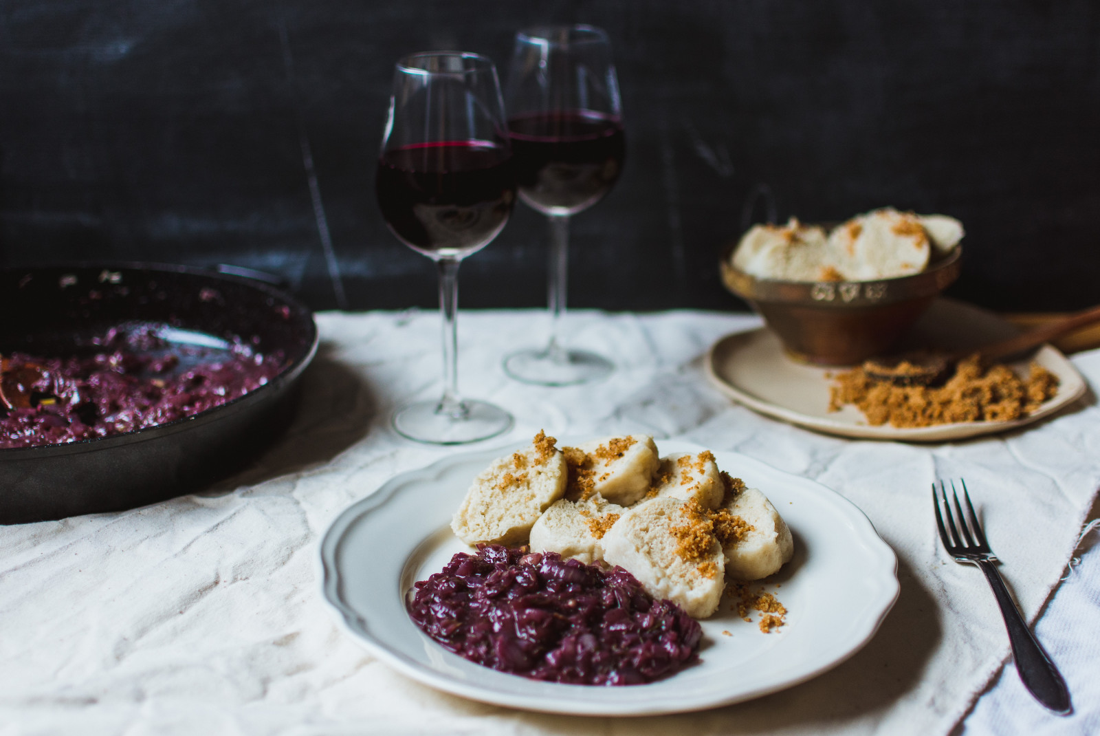 White plate with food next to two glasses of wine