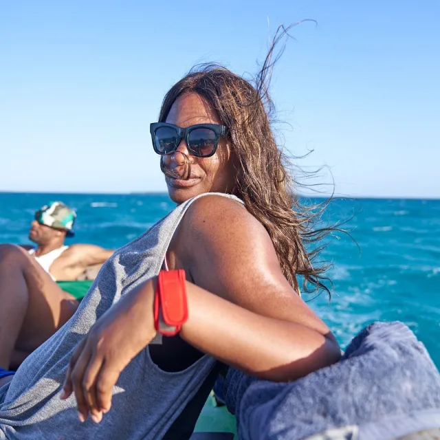 Travel Advisor Jennifer Mouloby in a gray shirt and black sunglasses on a boat.