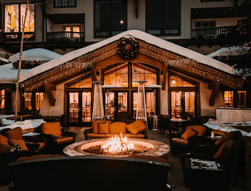 chairs and tables with a fire pit outdoors at night