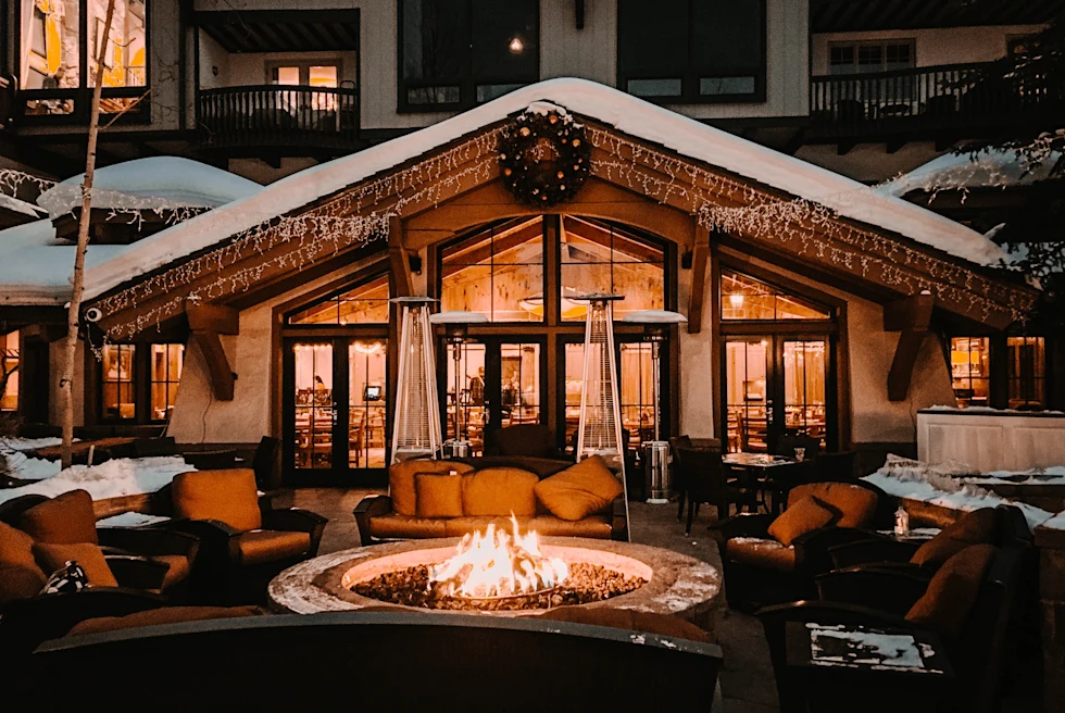 chairs and tables with a fire pit outdoors at night