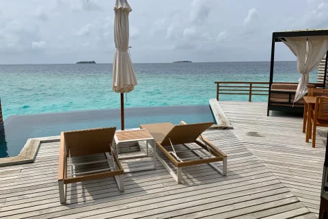 two loungers on a wooden deck overlooking the sea