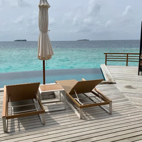 two loungers on a wooden deck overlooking the sea