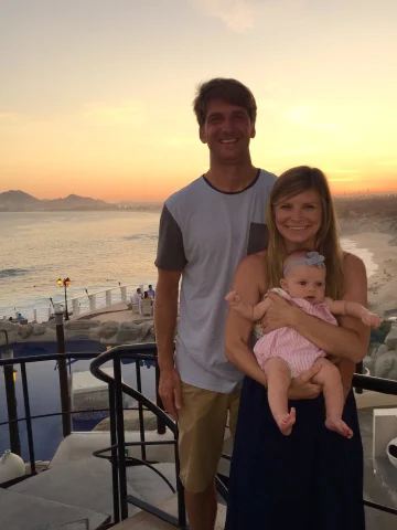 Travel advisor Jena Krinock with partner and baby at Sunset Monalisa restaurant overlooking the ocean at sunset