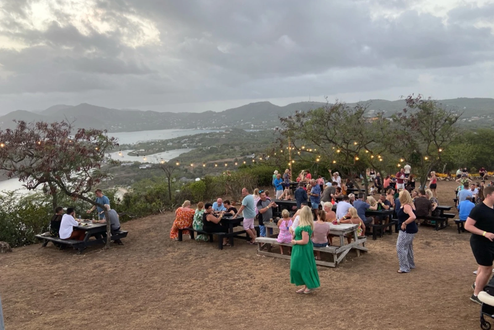 picnic tables at the top of a lookout over an island at sunset